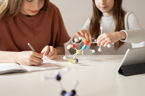 2 girls working with molecule models